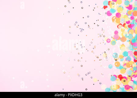 Festive pink background with colorful confetti and sparkles. Stock Photo