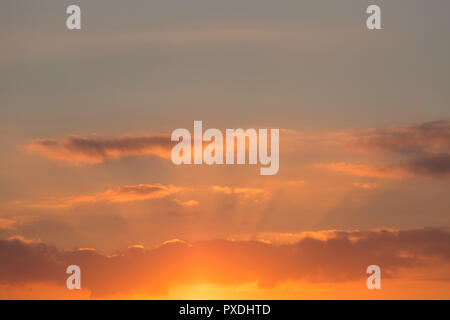 Crepuscular rays shining through orange clouds at Seasalter, Whitstable, Kent, UK. Stock Photo