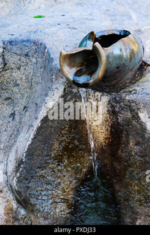 clay jug,water is drop from clay jug in the garden. Stock Photo