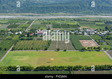 Paraglider landing on field, circle and heart shape on green grass field,countryside aerial view, at Luye Township, Taitung County, Taiwan Stock Photo