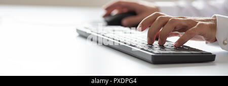 Wide view image of businessman using office computer keyboard. Stock Photo