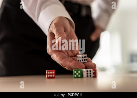 Business risk concept - businessman throwing dices on office desk. Stock Photo