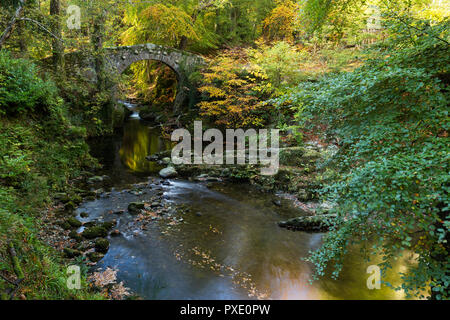 Newcastle,  N.Ireland, 21st October, 2018. UK Weather: Sunny intervals in the afternoon after a grey wet morning.  Lovely afternoon for a walk around Tollymore Forest Park to enjoy the autumn colours. Foley's Bridge over the River Shimna. Credit: Ian Proctor/Alamy Live News