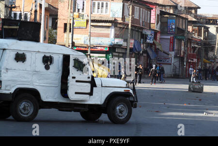 Srinagar, Kashmir. 22nd Oct 2018. .Kashmiri Muslim protesters shout slogans as they throw stones at Indian police vehicle , during the protest .The Joint Resistance Leadership (JRL), a separatist conglomerate headed by Syed Ali Geelani, Mirwaiz Umer Farooq and Muhammad Yasin Malik, called the shutdown against seven people were killed in explosion after an encounter in Kulgam district yesterday. Over 40 were injured in the blast and the clashes that followed. ©Sofi Suhail/Alamy Live News Stock Photo