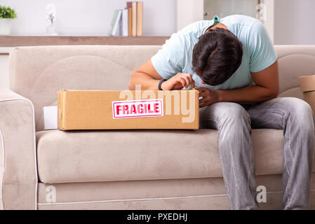 Man opening fragile parcel ordered from internet Stock Photo