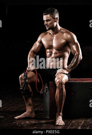 Male sitting after using resistance bands after training exercise Stock Photo