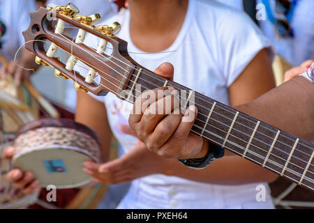 Detail of guitarist's hands and his acoustic guitar at an outdoor samba presentation Stock Photo