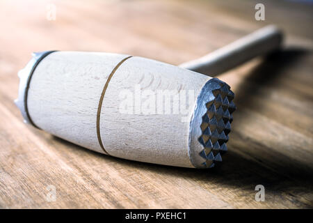 A Wooden Meat Mallet Lying Down On A Table Stock Photo
