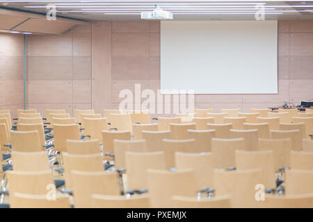 Empty wooden seats in a cotmporary lecture hall. Stock Photo