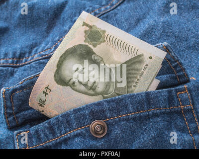 Chinese Yuan / Renminbi banknotes with pocket - metaphor for personal earnings, Chinese wages, wage levels, China garment industry. Stock Photo