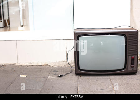 An old broken TV left on the street. High angle view Stock Photo