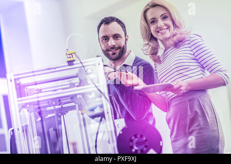 Beautiful businesswoman standing near the programmer working in her office Stock Photo