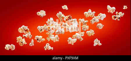 Popcorn isolated on red background. Falling or flying popcorn. Close-up Stock Photo