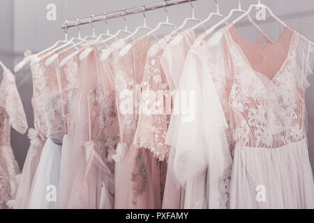 Beautiful wedding dresses hanging on hangers in the shop Stock Photo