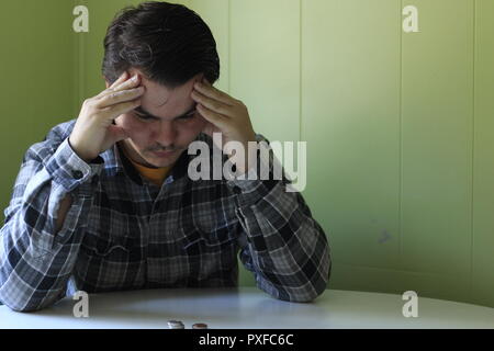 Thoughtful serious young man lost in thoughts in front of laptop, focused businessman or absent-minded student thinking of problem solution, worried p Stock Photo