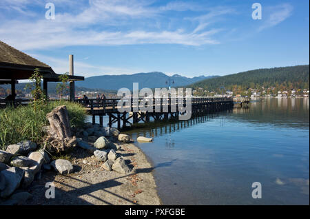 Pier at Rocky Point Park in Port Moody, BC, Canada on a sunny Autumn day.  Burrard Inlet and mountains, Metro Vancouver urban park. Stock Photo