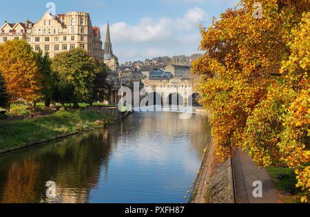 The famous landmarks of Pulteney Weir and Pulteney Bridge surrounded by vibrant autumnal trees on the River Avon in Bath, UK. Stock Photo