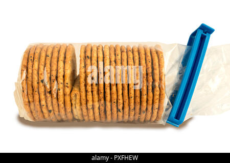 'The Odd One Out' A packet of clear cellophane wrapped biscuits with one faulty folded cracker illustrating a problem or failure in quality control. Stock Photo