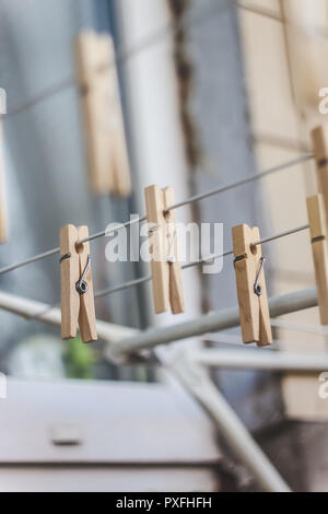 Wooden clothespins on a clothesline, blur, light photo. The concept of eco-consumption, the use of natural materials, awareness. Stock Photo
