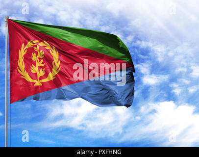 National flag of Eritrea on a flagpole in front of blue sky. Stock Photo