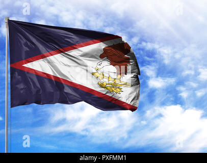 National flag of American Samoa on a flagpole in front of blue sky. Stock Photo