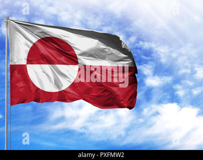 National flag of Greenland on a flagpole in front of blue sky.
