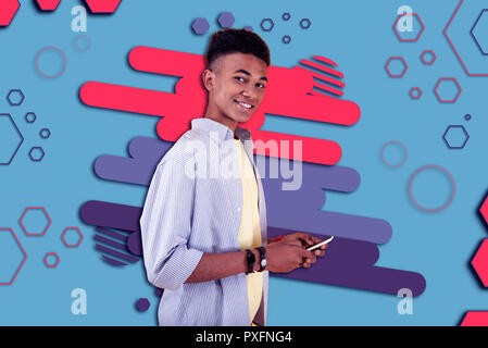 Beaming mulatto boy smiling after reading positive text message from friend Stock Photo