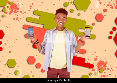 Cheerful mulatto boy feeling happy while receiving new smartphone for birthday Stock Photo