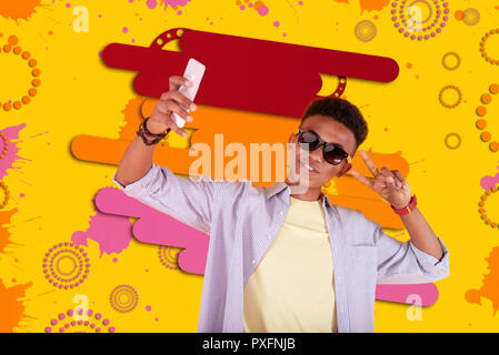 Cool mulatto teenager wearing dark sunglasses making selfie using his smartphone Stock Photo