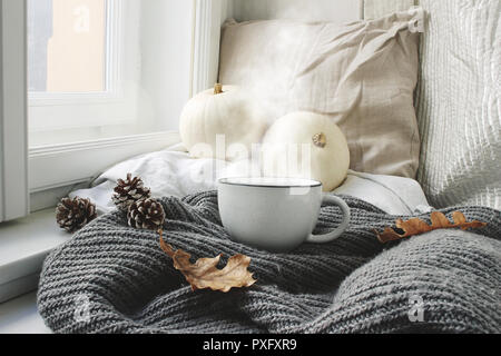 Cozy autumn morning breakfast in bed still life scene. Steaming cup of hot coffee, tea standing near window. Fall, Thanksgiving concept, white pumpkin Stock Photo