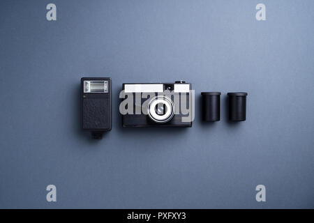 Analog camera and other accessories over gray background Stock Photo