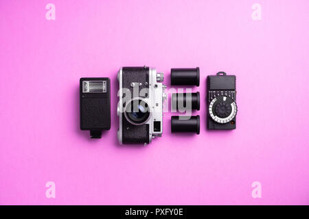 Analog camera and other accessories over pink background Stock Photo