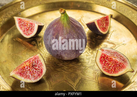 Group of figs on vintage copper dish with traditional oriental ornament. Stock Photo