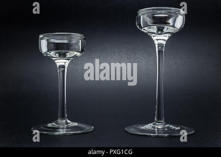 Two glass candlesticks standing on a black, shiny background. Stock Photo