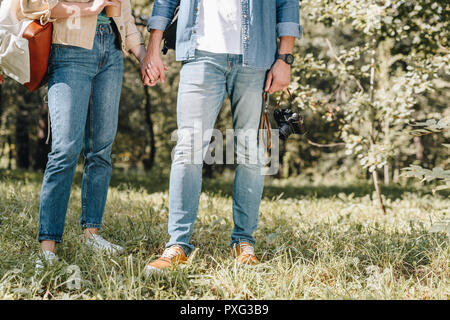 cropped shot of couple holding hands in park Stock Photo