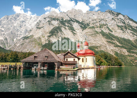 Classic panoramic view of Lake Konigssee with world famous Sankt Bartholomae pilgrimage church and Watzmann mountain on a beautiful sunny day in summer, Berchtesgadener Land, Bavaria, Germany Stock Photo