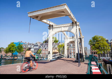 Amsterdam Magere brug Amsterdam Skinny bridge Amsterdam  spanning the river Amstel woman riding a bike Amsterdam Netherlands Holland EU Europe Stock Photo