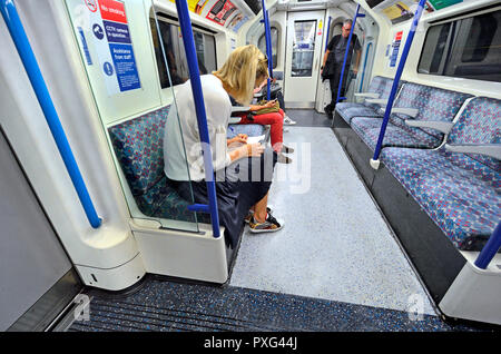 Woman marking work on an underground train, London, England, UK. Stock Photo