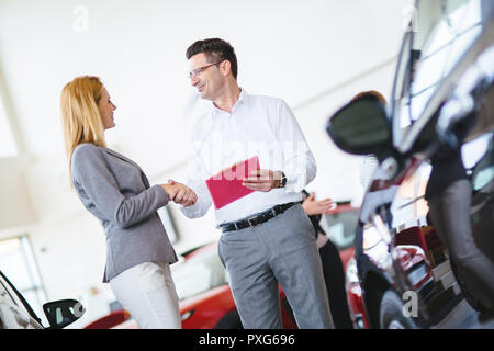 Successful businessman in a car dealership - sale of vehicles to customers Stock Photo