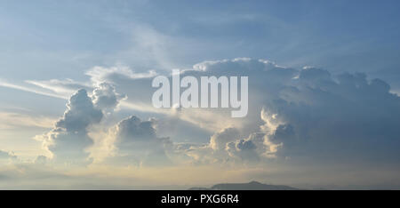 Cumulonimbus cloud formations on tropical sky with horizon is turning yellow at sunset , Nimbus moving , Gray clouds hunk Stock Photo