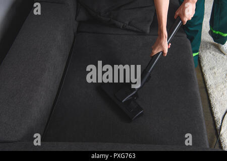 high angle view of person cleaning furniture with vacuum cleaner, upholstery cleaning Stock Photo