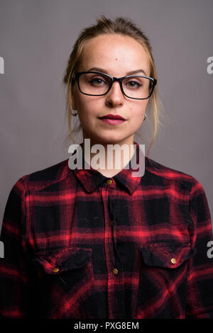 Young beautiful woman with blond hair wearing eyeglasses against Stock Photo