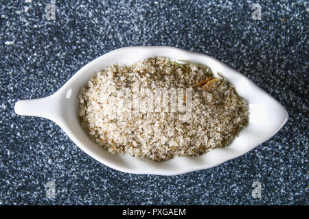 Different types of salt in glass bowls on a dark gray table. Background for advertising salt. Table salty. Salted food Stock Photo