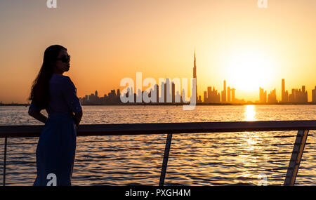 Woman enjoying Dubai landmark view at sunset Stock Photo