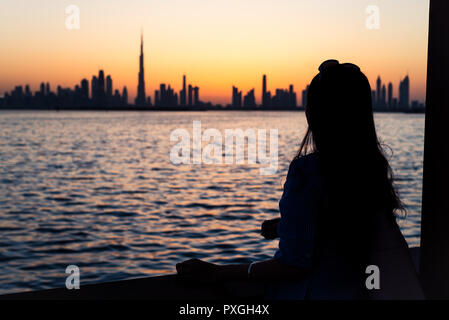 Woman enjoying Dubai landmark view at sunset Stock Photo