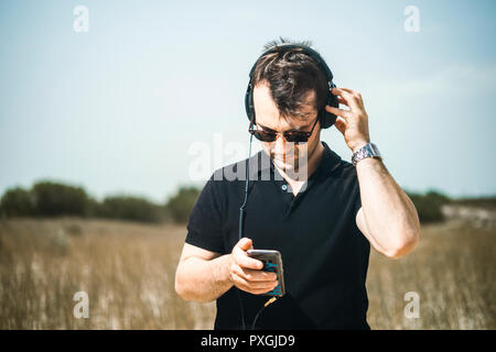 Handsome young man playing music from his smartphone on his headphones Stock Photo