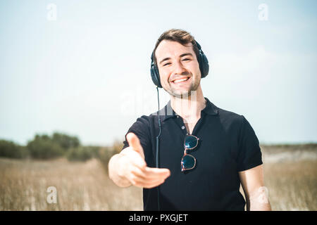 Young attractive man wearing black enjoying music on his headphones Stock Photo