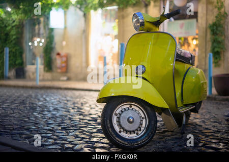 Classic Italian motorbike parked on cobblestone street Stock Photo