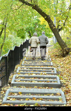 Happy senior couple in autumn park walking Stock Photo