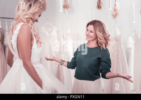 Cheerful nice blonde woman helping her daughter Stock Photo